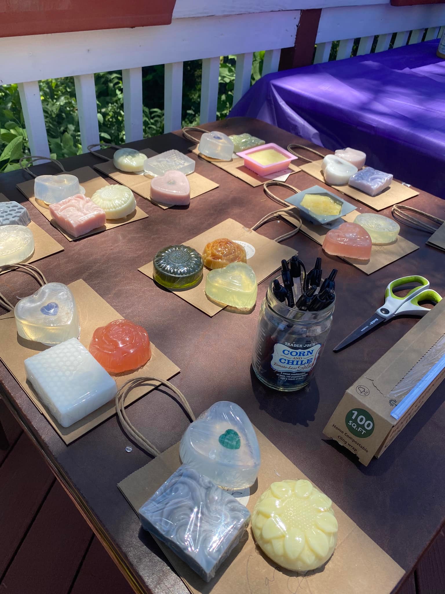 Variety of bar soaps laid out on a table along with soap making supplies. 