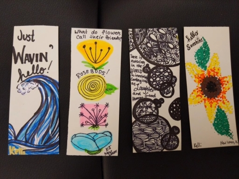 Four example bookmarks decorated with paint markers. 