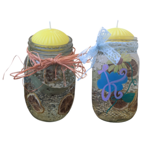 Two jar filled with water beads, lemon slices and leaves topped with floating candles.