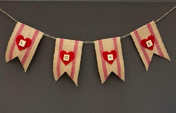 Stripped burlap banner with red hearts and the letters L O V E on a gray background.